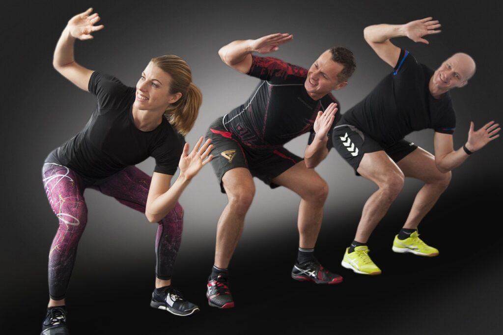 Three people a woman and two men squatting doing a CrossFit exercise.