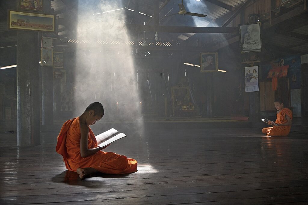 a young buddhist monk reading and practicing yoga and meditation