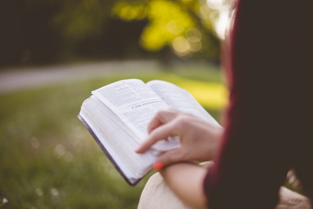 a women sitting with an open book on her lap 