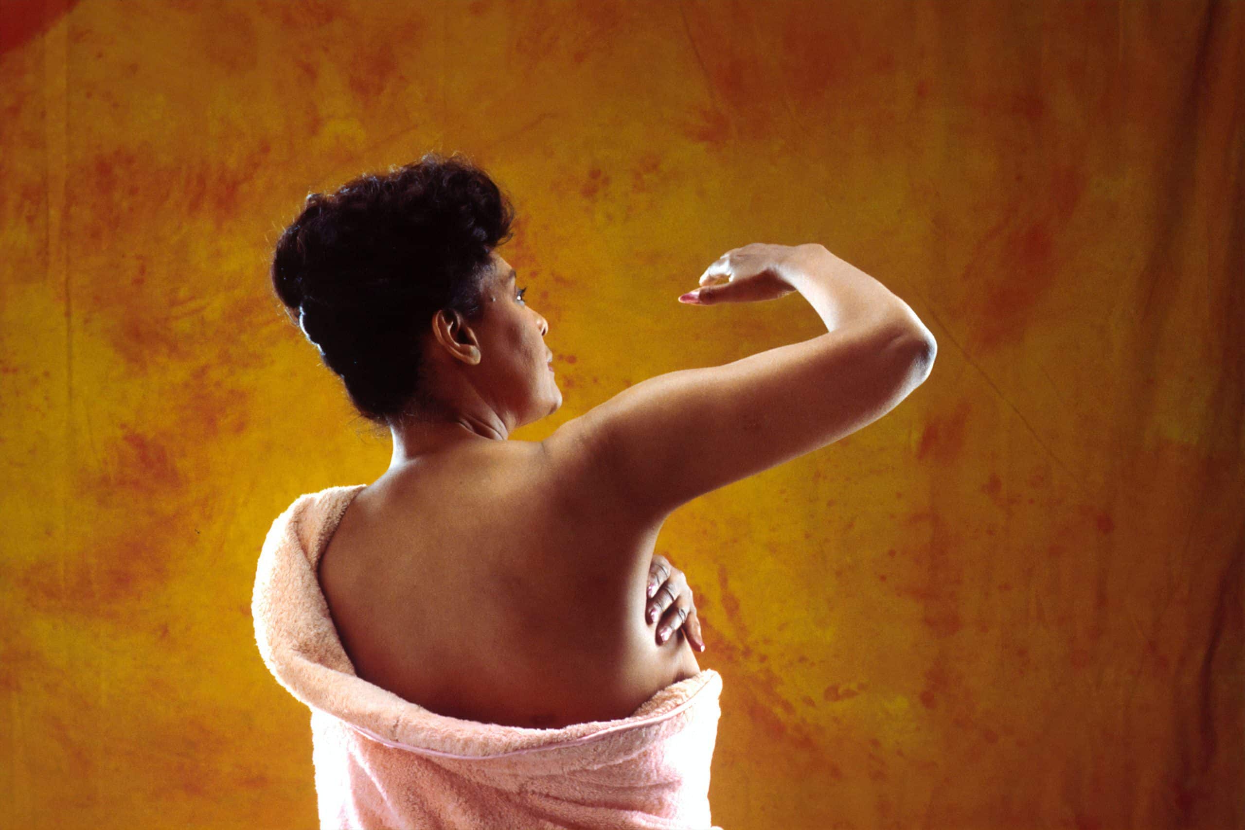 Woman giving herself a breast exam.