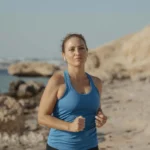 Woman jogging at the beach to unlock health and wellness