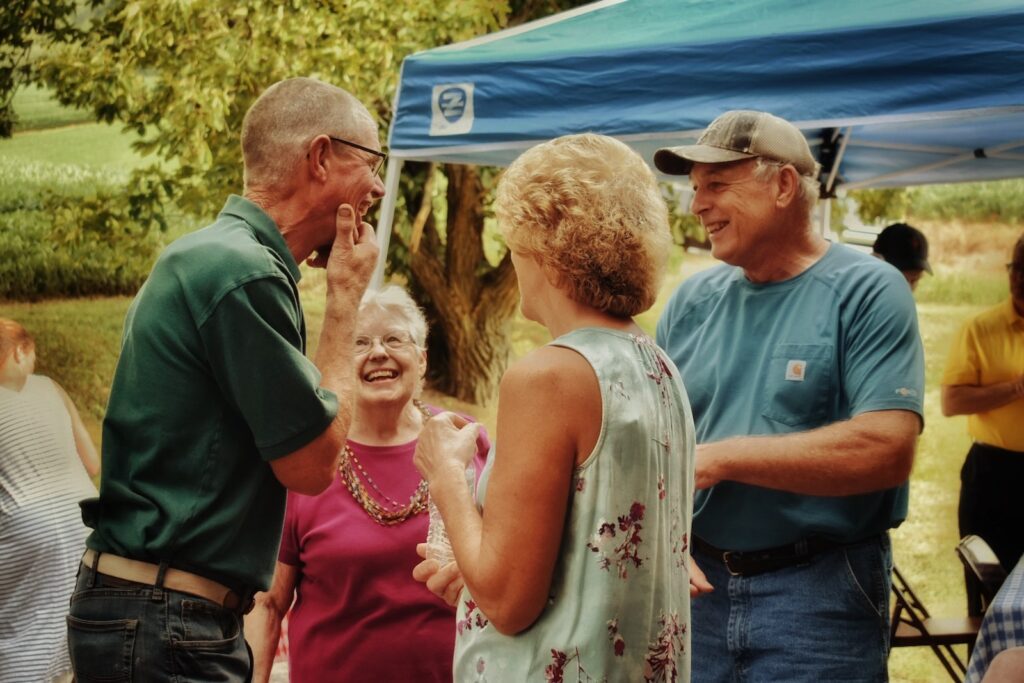 four seniors outside talking laughing and enjoying their golden years