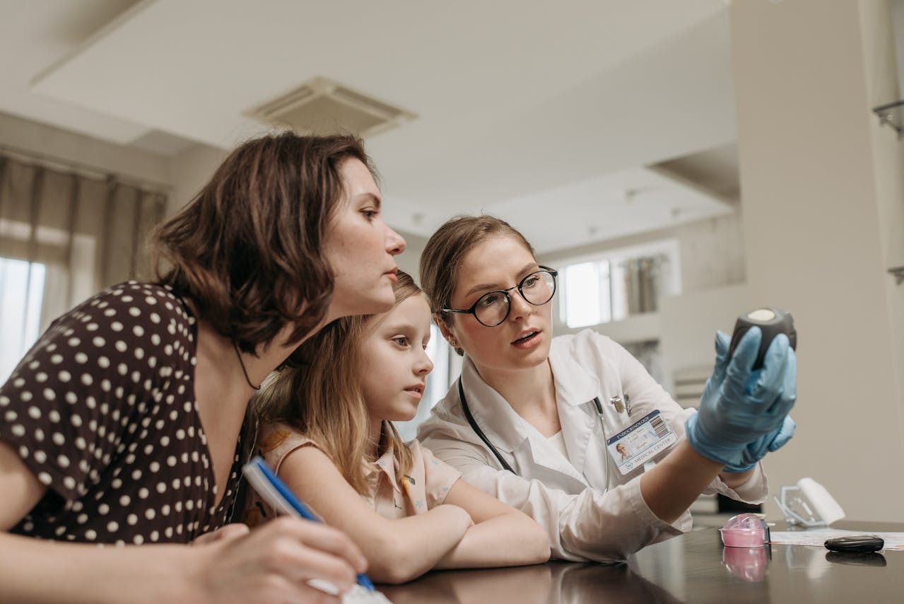 a female doctor explaining information to a mother and her daughter